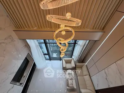 Luxurious living room with high ceiling, elegant chandelier, and modern decor in a high-rise apartment.