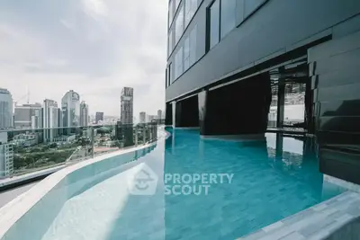 Luxurious rooftop pool with stunning city skyline views in modern high-rise building.