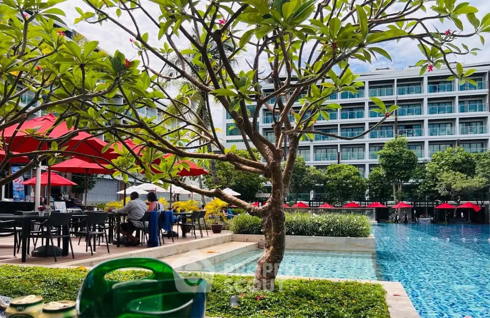 Luxurious poolside view with modern building and lush greenery, perfect for relaxation and leisure.