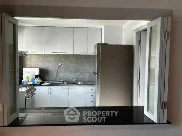 Modern kitchen with sleek cabinets and stainless steel appliances in open layout.