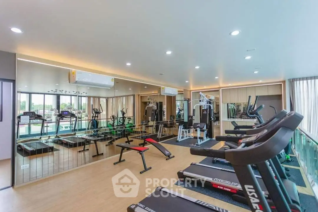 Modern gym with state-of-the-art equipment and mirrored walls in luxury real estate property.