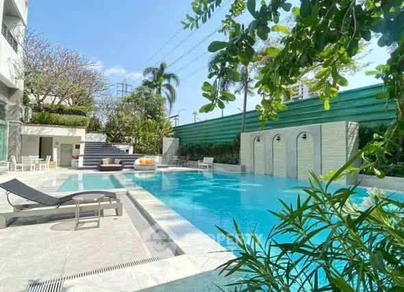 Luxurious outdoor pool area with lush greenery and modern design, perfect for relaxation and leisure.