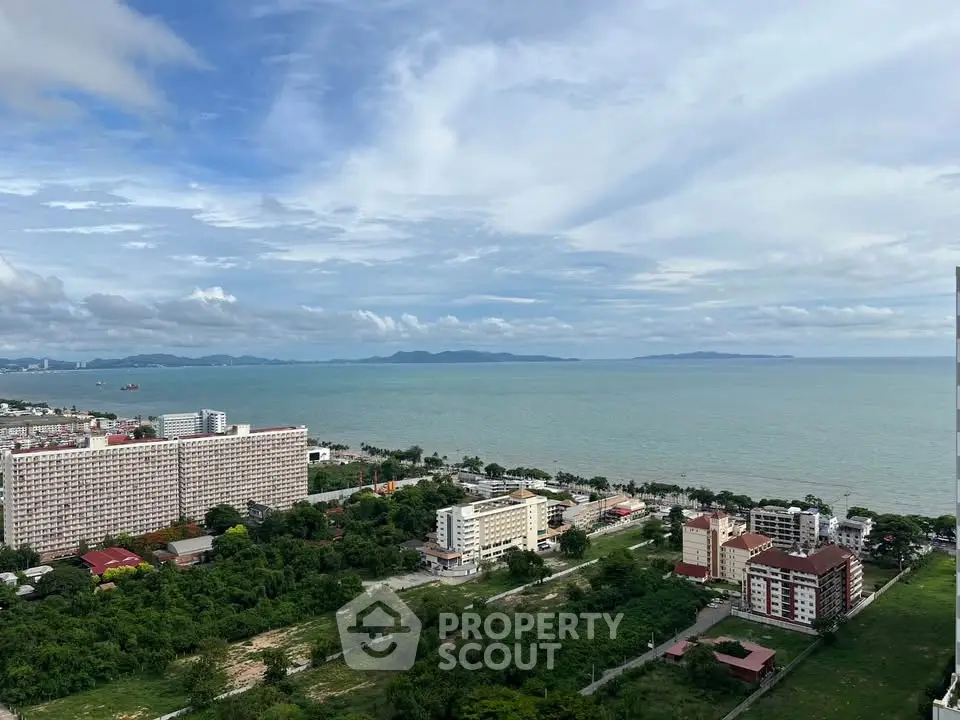 Stunning coastal view from high-rise building overlooking ocean and cityscape, perfect for serene living.