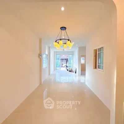 Spacious open-plan living area with elegant lighting and glossy tiled floors