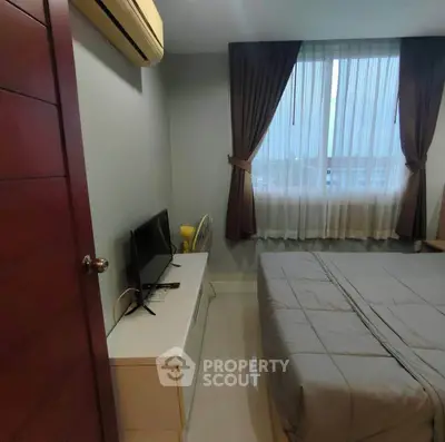 Cozy bedroom with modern decor, featuring a large window and air conditioning for comfort.