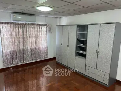Spacious room with large wardrobe and polished wooden floors