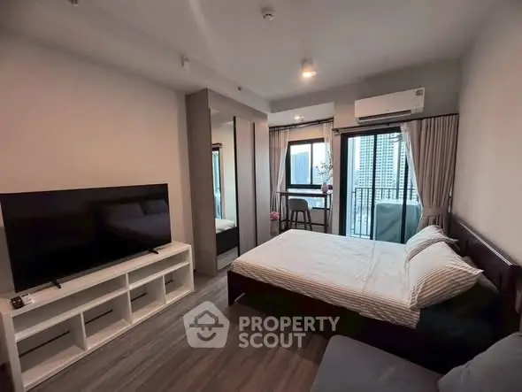 Modern bedroom with large TV and balcony view in stylish apartment