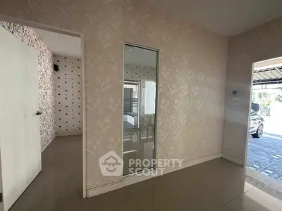 Spacious interior with elegant wallpaper and large window, ideal for modern living.