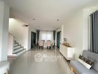 Spacious modern living room with elegant dining area and sleek staircase