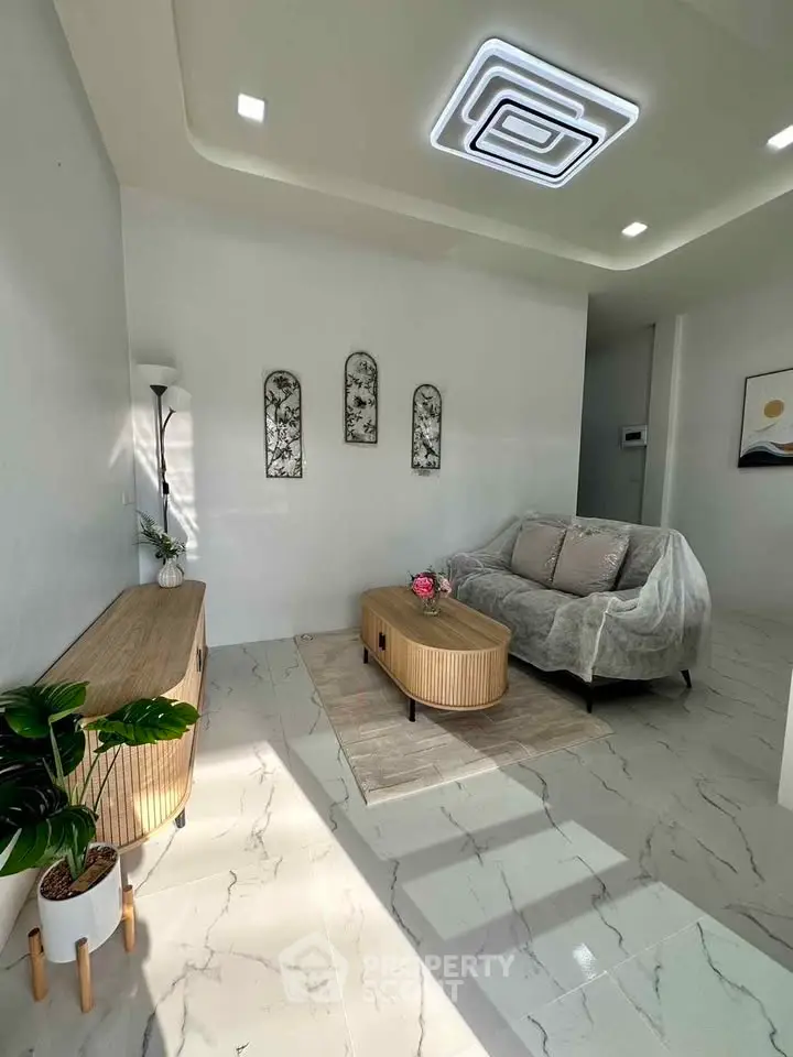 Modern living room with stylish furniture and elegant decor, featuring a cozy sofa and chic lighting.
