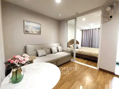 Modern apartment interior with cozy living room and elegant bedroom, featuring stylish decor and wooden flooring.