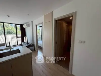Modern apartment interior with open layout and large windows offering natural light and scenic views.