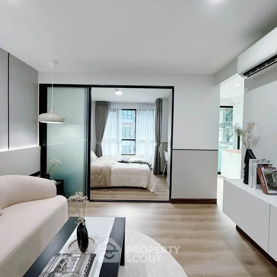 Modern open-plan living room with cozy bedroom view and stylish decor