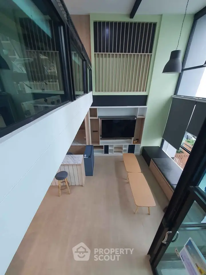 Modern loft-style living room with high ceilings and large windows