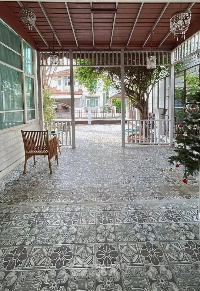Charming patio with decorative tiles and garden view, perfect for outdoor relaxation.