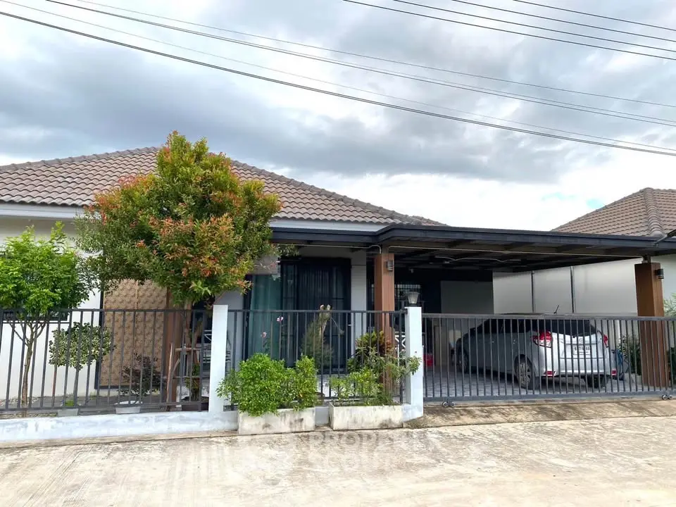 Charming single-story home with a spacious driveway and lush greenery, perfect for family living.