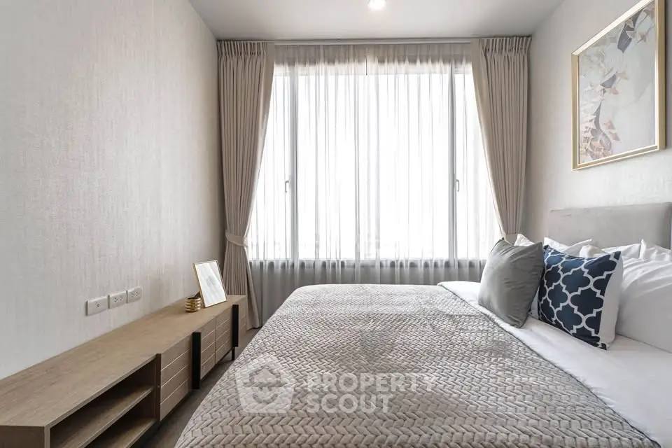 Modern bedroom with stylish decor and large window offering natural light