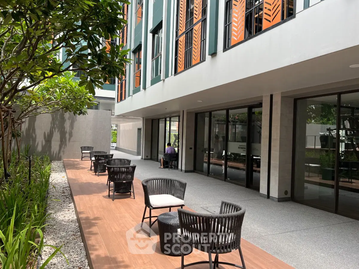 Modern apartment building with stylish outdoor seating area and lush greenery