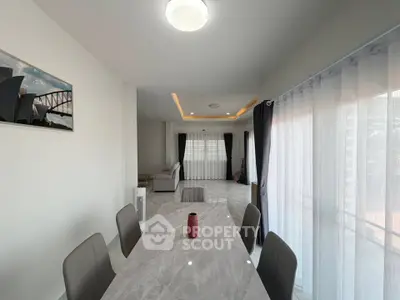 Spacious dining area with elegant decor and natural light in modern apartment.