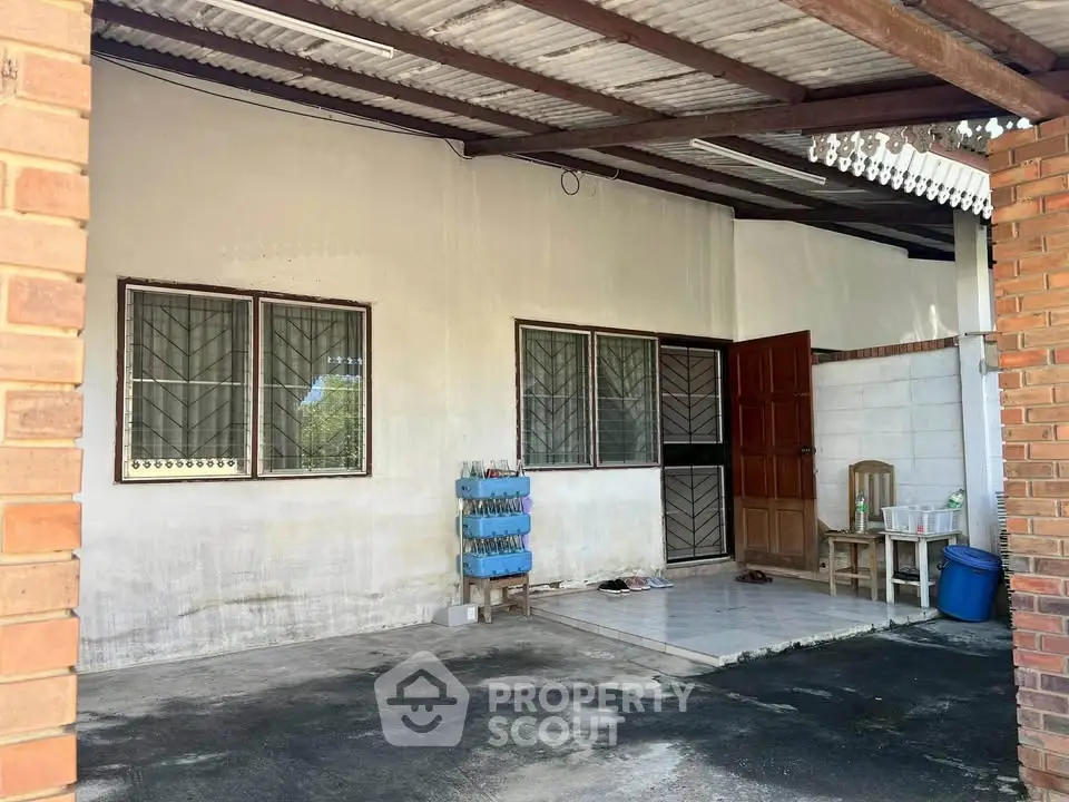 Charming covered patio with rustic brick accents and ample space for outdoor activities.