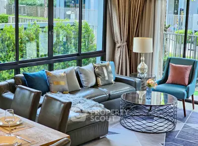 Luxurious living room with modern furniture and large windows overlooking greenery.