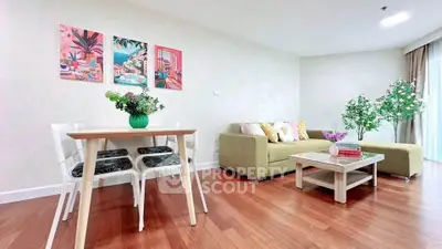 Spacious living room with modern decor and wooden flooring, featuring a cozy sofa and dining area.
