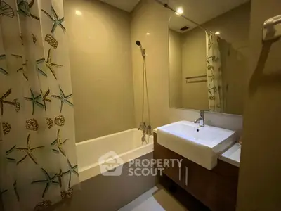 Modern bathroom with bathtub and stylish vanity in a cozy apartment.
