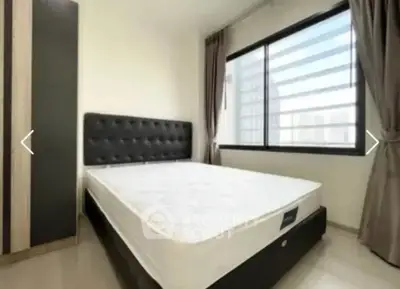 Modern bedroom with large window and stylish bed in a bright apartment.