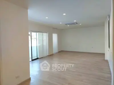 Spacious modern living room with wooden flooring and large windows