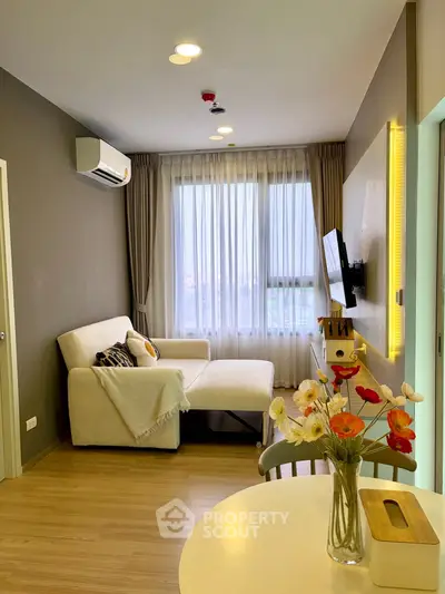 Modern living room with cozy sofa and wall-mounted TV, featuring elegant decor and natural light.