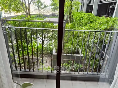 Charming balcony with lush greenery and city view, perfect for relaxation and enjoying nature.