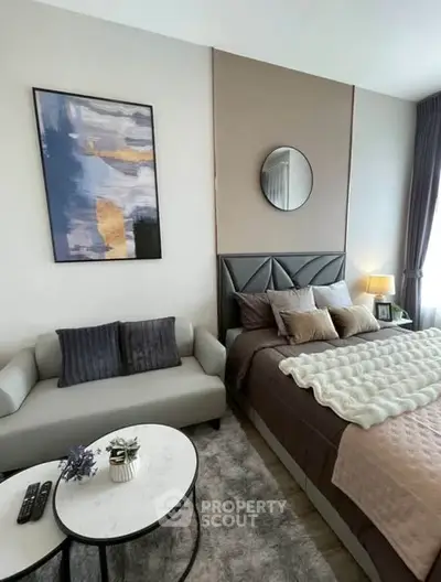 Stylish bedroom with modern decor, cozy seating area, and elegant artwork, perfect for relaxation and comfort.