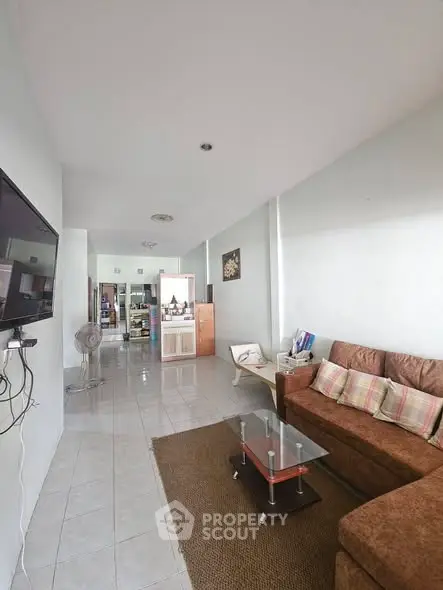 Spacious living room with modern decor and wall-mounted TV, perfect for relaxation and entertainment.