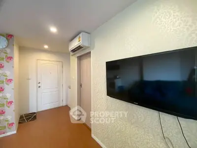 Modern apartment interior with wall-mounted TV and air conditioning unit.