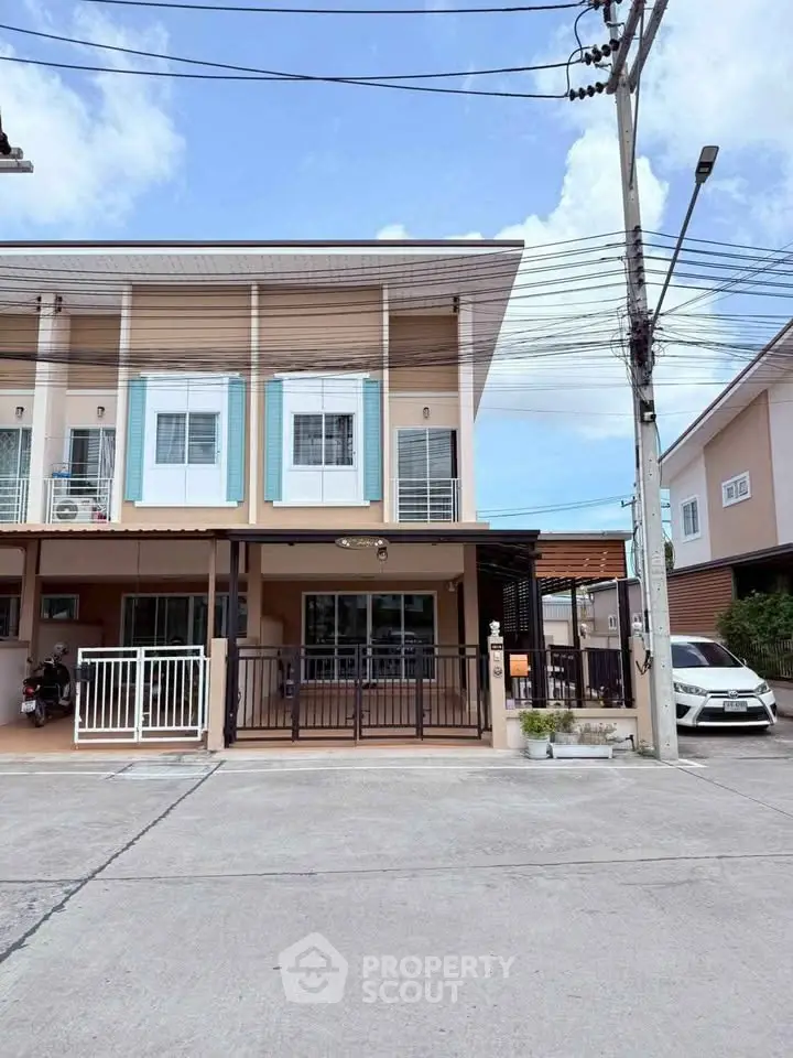 Charming two-story townhouse with modern facade and spacious driveway in a serene neighborhood.