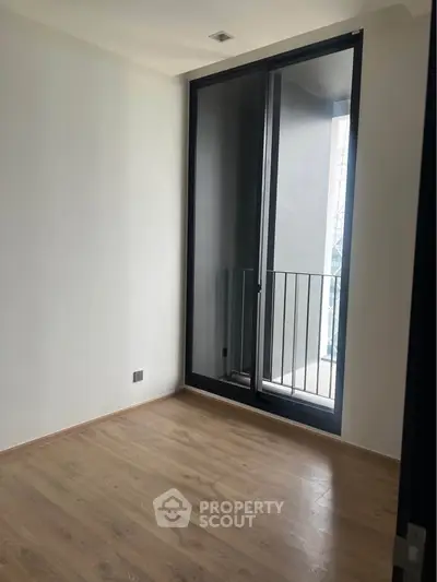 Minimalist room with large window and wooden flooring, perfect for modern living.