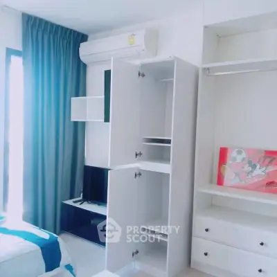 Modern bedroom with built-in wardrobe and air conditioning, featuring bright natural light and sleek design.