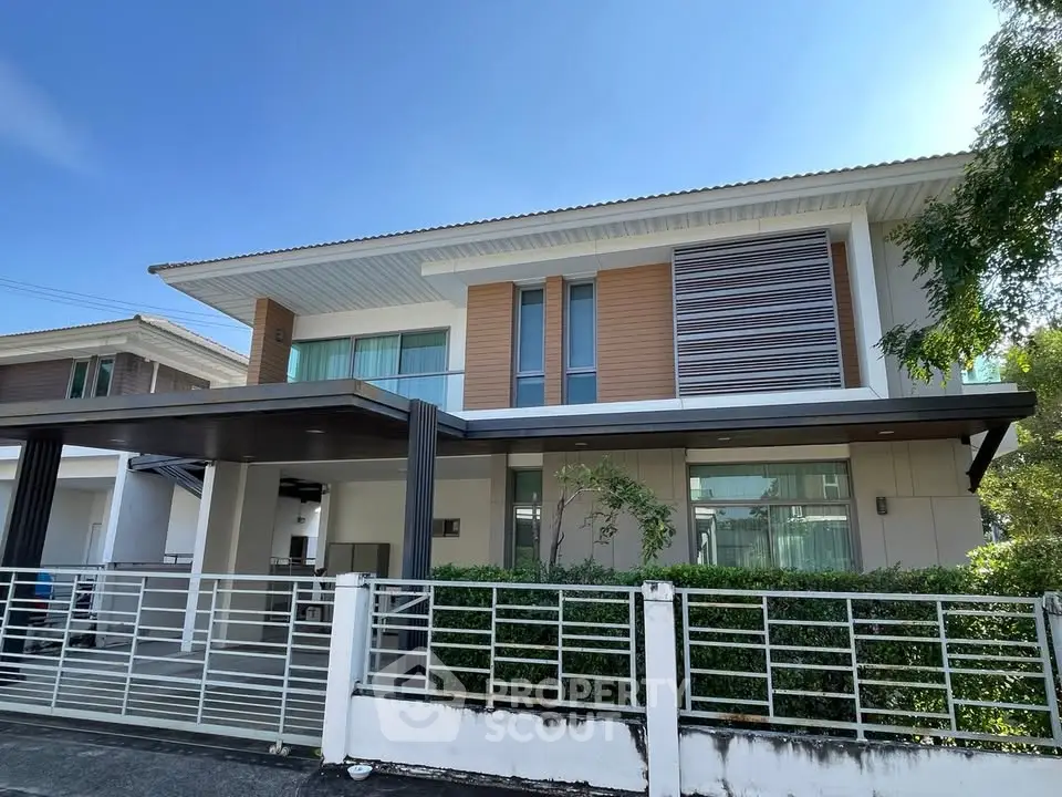 Modern two-story house with sleek design and spacious driveway in a serene neighborhood.