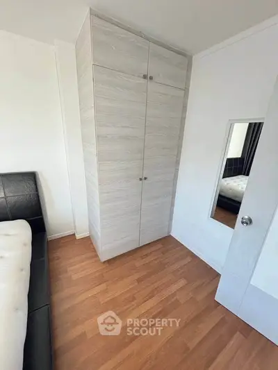 Modern bedroom with sleek wardrobe and hardwood flooring