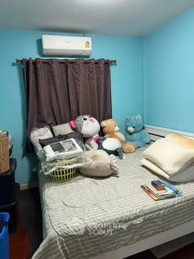Cozy bedroom with plush toys and air conditioning, perfect for a comfortable living space.