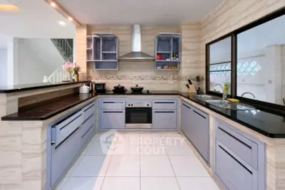 Modern kitchen with sleek cabinetry and built-in oven, featuring an open layout and stylish design.