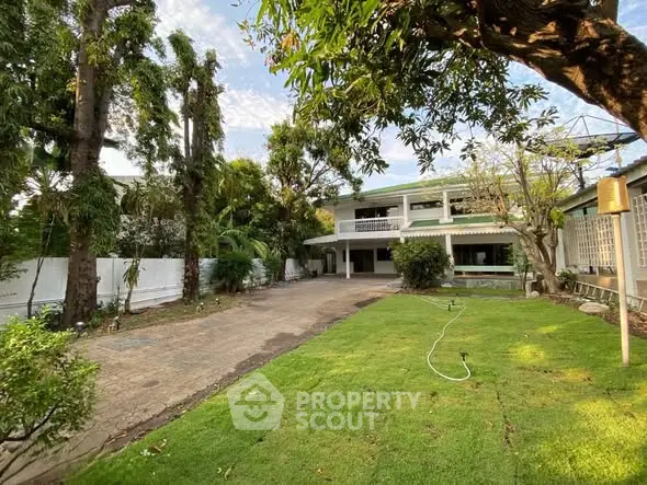 Charming two-story house with lush garden and spacious driveway.