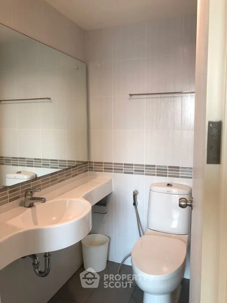 Modern bathroom with sleek fixtures and large mirror in a contemporary home.