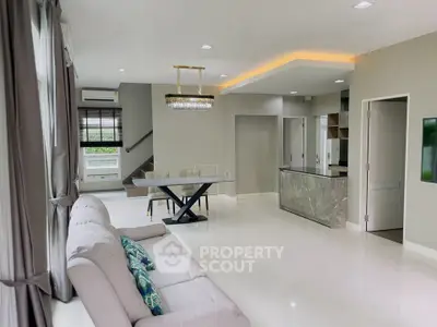 Spacious modern living room with elegant dining area and stylish kitchen in open layout.