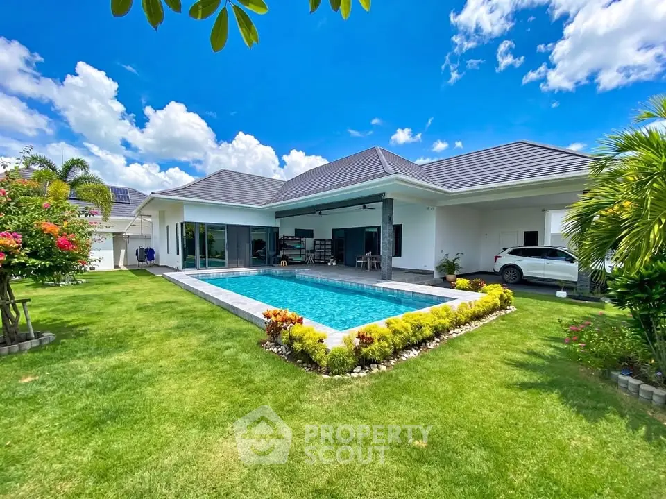 Luxurious villa with private pool and lush garden under a clear blue sky.