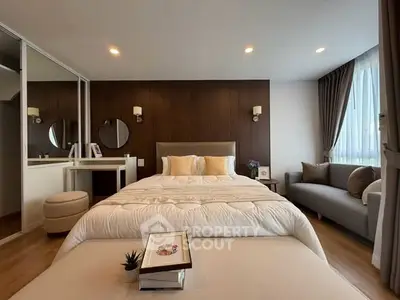 Luxurious bedroom with elegant decor, featuring a cozy bed, stylish seating, and ample natural light.