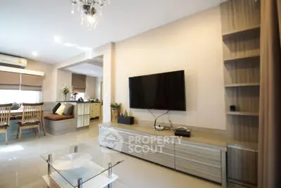 Modern living room with sleek TV setup and dining area, perfect for family gatherings.