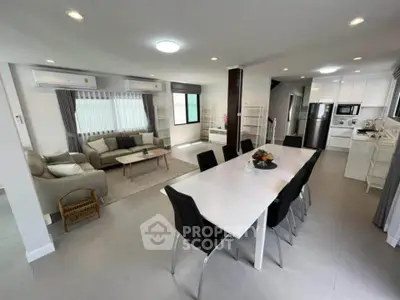 Spacious open-plan living and dining area with modern kitchen and stylish decor.