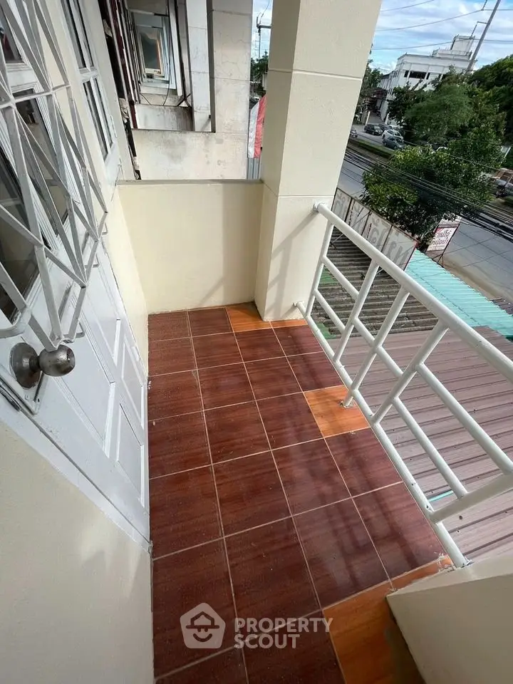Charming balcony with tiled flooring and street view, perfect for relaxation and enjoying the outdoors.