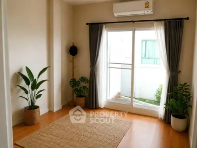 Bright and airy room with wooden flooring, large window, and stylish decor plants.